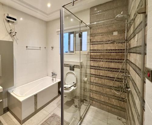 a bathroom with a shower and a toilet and a sink at Ivory's Nest in Accra