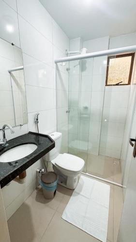 a bathroom with a toilet and a glass shower at Ed Flat Valdeliza Pio in Teresina