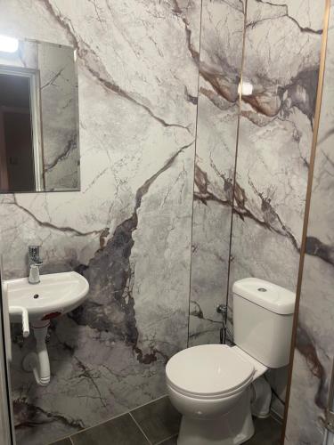 a bathroom with a white toilet and a sink at Motel San Marino in Kuru-Cheshme