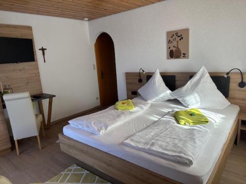 a bedroom with a bed with two yellow shoes on it at Ferienhotel Münch in Neukirchen beim Heiligen Blut