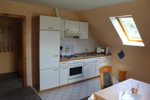 a kitchen with white appliances and a table and a window at Steenshof in Klötzin