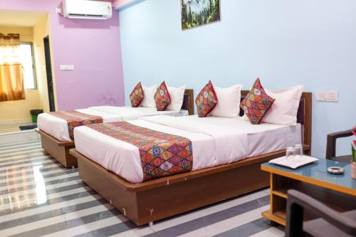 two beds in a hotel room with at Hotel Dipak in Himatnagar