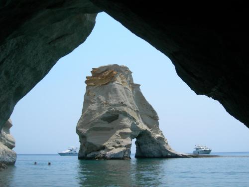 a rock formation in the water with boats in the background at Villa Zampeta in Adamas