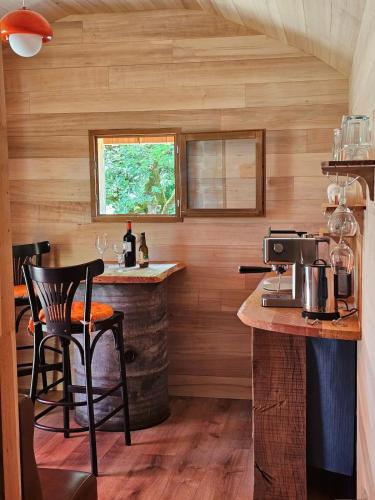 a kitchen with a bar in a tiny house at La nuitée belle in Cénevières
