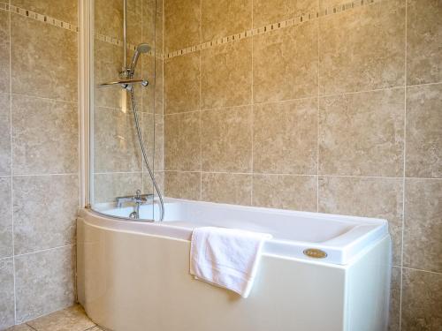 a bathroom with a bath tub with a towel at Dingle View - 37 Tír Na Fiuise in Dingle