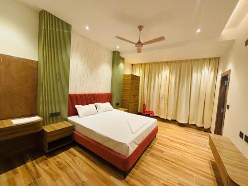 a bedroom with a bed and a green wall at Hotel Picnic Garden in Patna