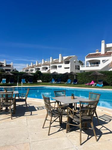 a table and chairs next to a swimming pool at Vila Nova- by Portugalferias in Carvoeiro