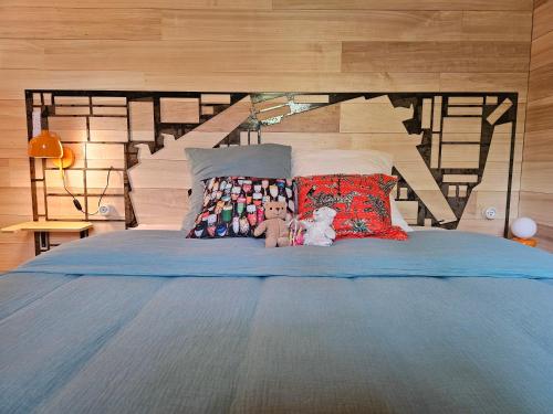 a bed with two stuffed animals sitting on it at La nuitée belle in Cénevières