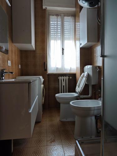 a bathroom with a toilet and a sink and a window at Casa Largo Giusti in Vercelli