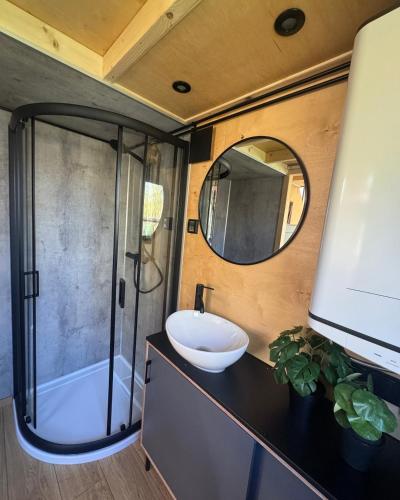 a bathroom with a sink and a shower and a mirror at Tiny House Porto op Domein Kiewit in Hasselt