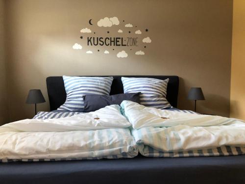 a bedroom with a king sized bed with clouds on the wall at Ferienwohnung Gaß in Kastellaun