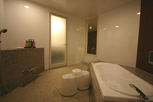 a bathroom with a white tub and a sink at Hotel VILLA ANNEX盛岡 in Morioka