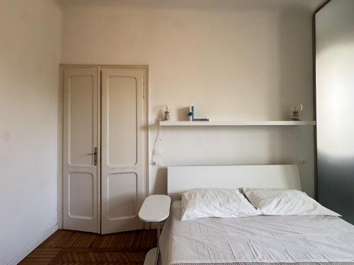 a bedroom with a white bed and a closet at René Apartments in Salsomaggiore Terme