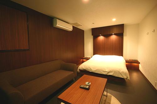 a hotel room with a bed and a couch at Hotel VILLA ANNEX盛岡 in Morioka