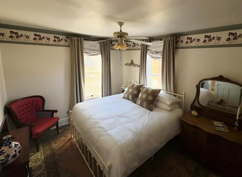 a bedroom with a bed and a mirror and a chair at Avery House Bed & Breakfast in Galena