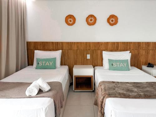 a hotel room with two beds with green pillows at STAY Cosmopolitan in Palmas