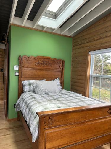 a bed in a room with a green wall at Cupids Guest House and SheShed in Brigus