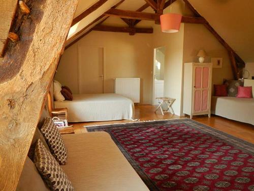 a bedroom with two beds and a rug in a room at La Peuterne in Mouazé
