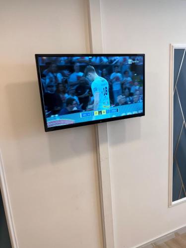telewizor z płaskim ekranem wiszący na ścianie w obiekcie Easy Boarding w mieście Neapol