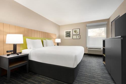 a hotel room with a large white bed and a window at Country Inn & Suites by Radisson, Dunn I-95 in Dunn