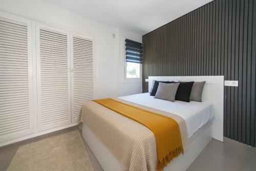 a bedroom with a large bed with white walls and windows at WELCS APARTAMENTO 342 PDA con terraza in Platja d'Aro
