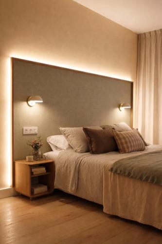 a bedroom with a large bed with two lights on it at Pension Nagusia in Basauri