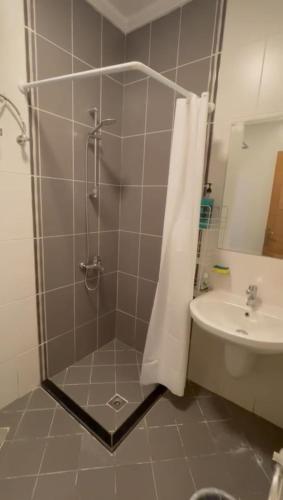 ein Badezimmer mit Dusche und Waschbecken in der Unterkunft صدى التلال in As Sifyānī