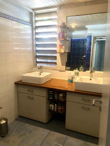 a bathroom with two sinks and a mirror at La villa bleue in Koungou