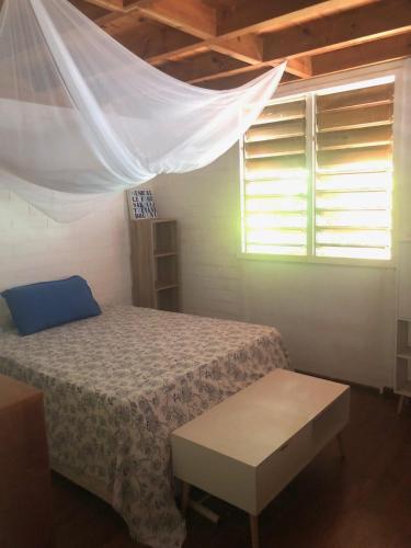 a bedroom with a bed and a window at La villa bleue in Koungou