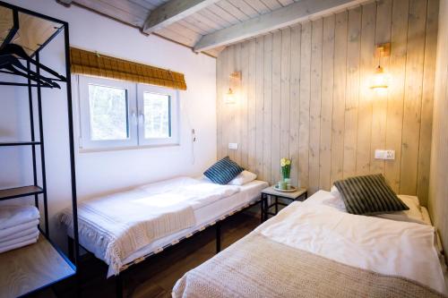 a room with two beds and a window at La Playa Resort & Camp Trzebinia in Trzebinia