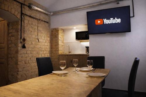 a table with wine glasses and a sign on the wall at Jacuzzi Loft in the Center of Riga in Riga