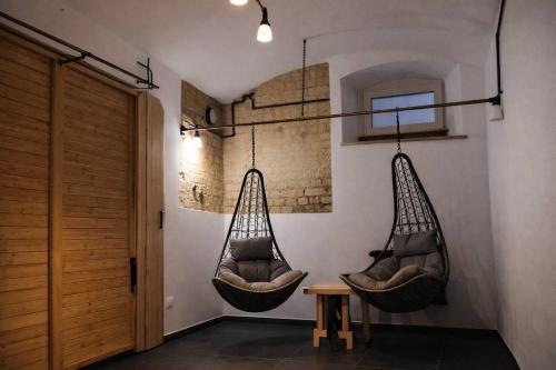 two hanging hammocks in a room with a table at Jacuzzi Loft in the Center of Riga in Riga
