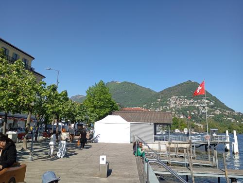 a group of people sitting on a dock near the water at Casa Willo in Bellinzona