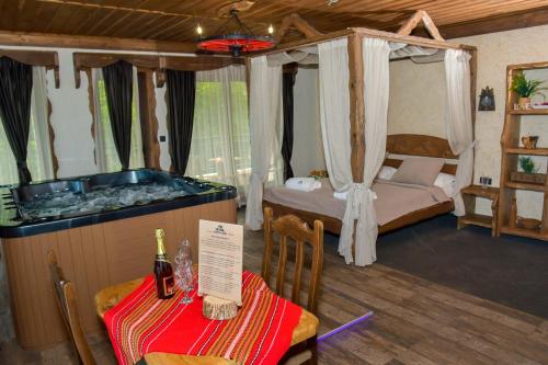 a room with a tub and a table and a bed at Complex Starite Kashti in Razvalini Balchikioy