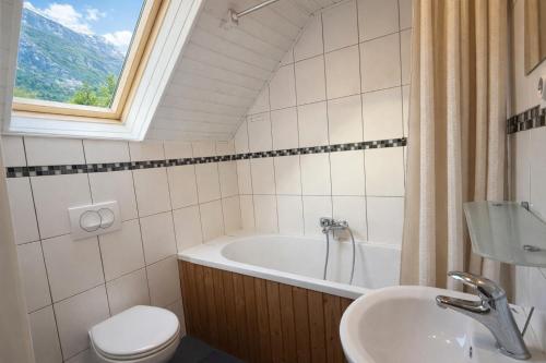 a bathroom with a tub and a toilet and a sink at Rose Cottage in Bovec
