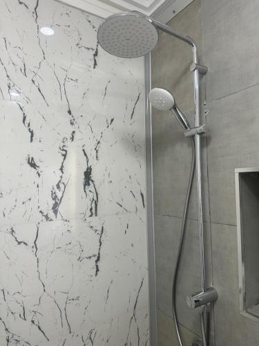 a shower in a bathroom with a marble wall at Villa Island Zembra in El Haouaria