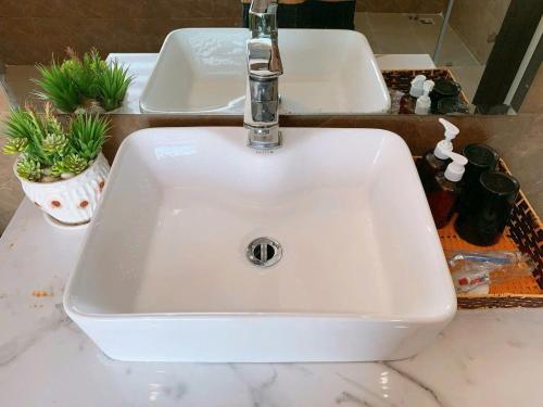 a white sink in a bathroom with two sinks at FLC Grand Villa BT31-26 in Sầm Sơn