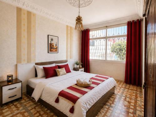 a bedroom with a large bed with red curtains at Cozy Guesthouse in Aourir near Tamraght in Aourir