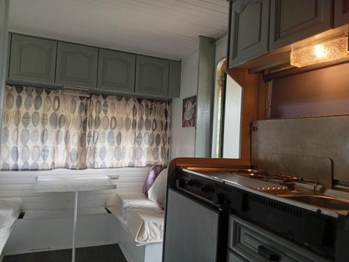 a kitchen with a stove and a couch in a room at Cabana do Gipsy in Ponte da Barca