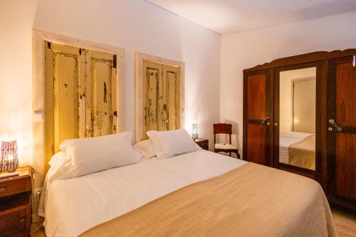 a bedroom with a white bed and a mirror at Casa Da Avo Clementina in Funchal