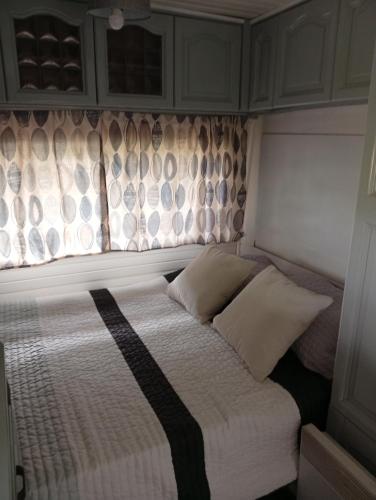 a bed in a small room with a window at Cabana do Gipsy in Ponte da Barca