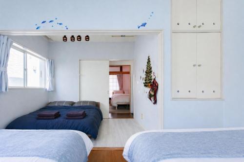 a bedroom with two beds and a christmas tree at 75m2 10people private house rental 8beds 8min Ikebukuro 13min Shinjuku 18min Shibuya Englishspeaking staff available in Tokyo
