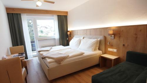 a bedroom with a white bed and a window at Hotel Sonnhof in Innsbruck