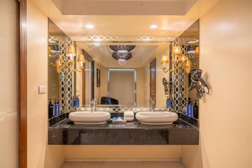 a bathroom with four sinks and a large mirror at Radisson Blu Hotel Ahmedabad in Ahmedabad