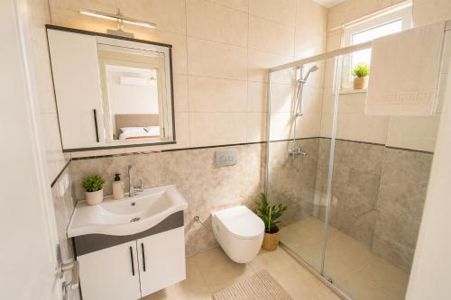 a bathroom with a toilet and a sink and a shower at Villa Maya in Ortaca