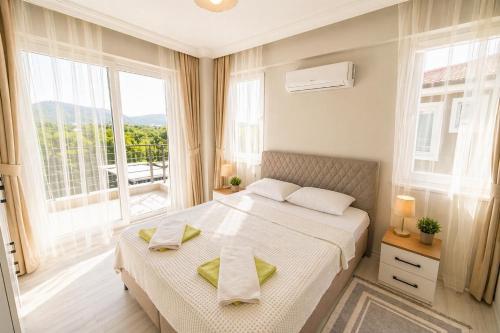 a bedroom with a bed and a large window at Villa Maya in Ortaca