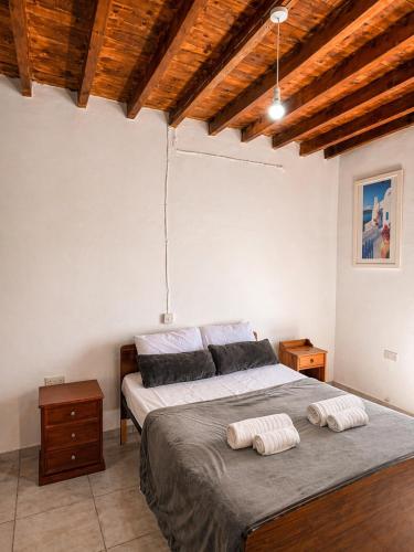 a bedroom with a bed with two pillows on it at Peyia traditional house in Paphos