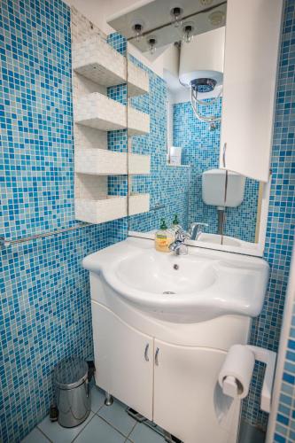 a bathroom with a white sink and blue tiles at MA-LO 1 in Pirovac
