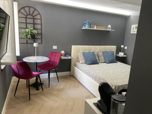 a bedroom with a bed and a table and chairs at Chagall Bijoux in Asti