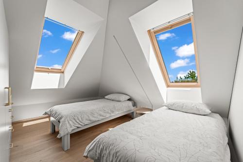 two beds in a room with two windows at Dunique Summer in Palanga